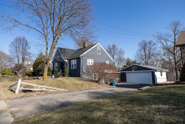 view of side of property featuring a garage, a chimney, and a yard