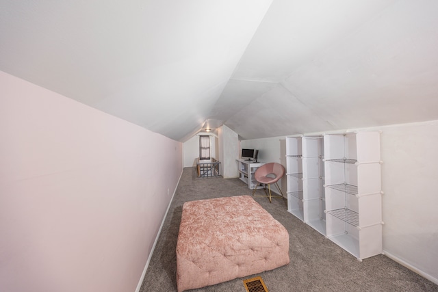 interior space with vaulted ceiling, carpet, visible vents, and baseboards