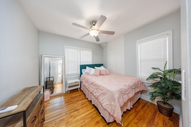 bedroom with multiple windows, light wood-type flooring, and ceiling fan