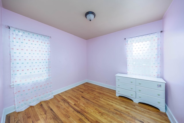 unfurnished bedroom with light wood-type flooring and baseboards