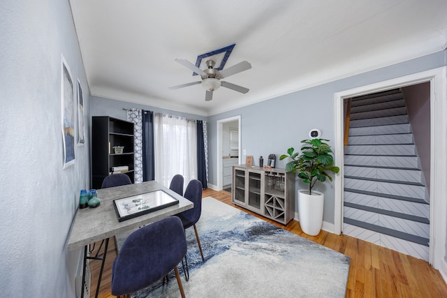 office area featuring wood finished floors, baseboards, and ceiling fan