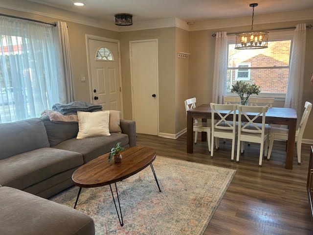 living area with plenty of natural light, baseboards, and wood finished floors