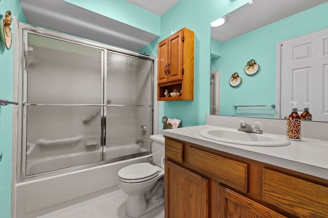 bathroom with toilet, combined bath / shower with glass door, vanity, and tile patterned flooring