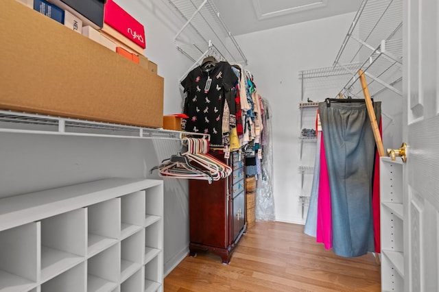 spacious closet with wood finished floors and attic access