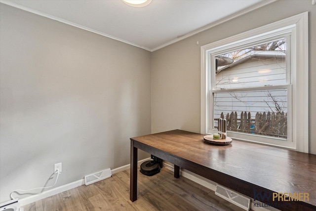 dining area featuring wood finished floors, visible vents, baseboards, ornamental molding, and baseboard heating