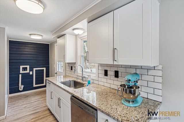 kitchen with a sink, backsplash, stainless steel dishwasher, white cabinetry, and light wood finished floors