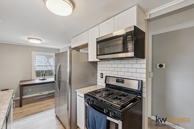 kitchen with tasteful backsplash, baseboards, light wood-style floors, white cabinets, and stainless steel appliances