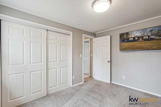 unfurnished bedroom with a closet, baseboards, and carpet floors