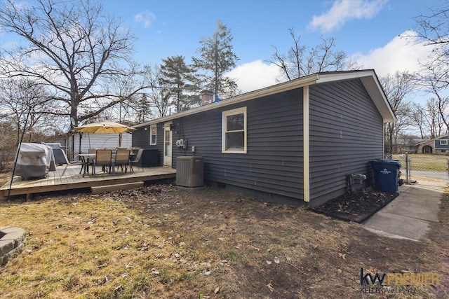 back of property featuring a gate, central AC unit, outdoor dining area, a chimney, and a deck