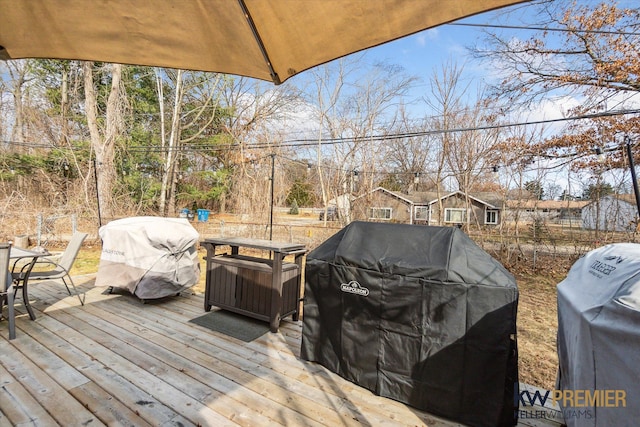 wooden deck featuring a grill and outdoor dining space