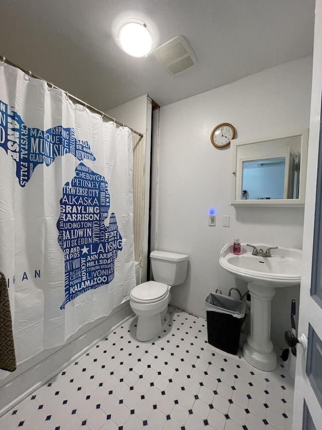 bathroom featuring a sink, visible vents, and toilet