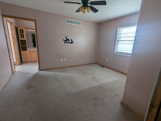 empty room featuring visible vents, baseboards, and ceiling fan