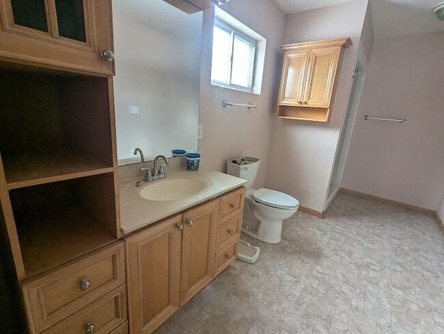 bathroom featuring baseboards, toilet, and vanity