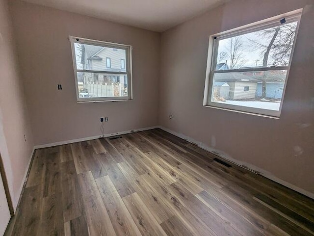 empty room featuring wood finished floors and baseboards