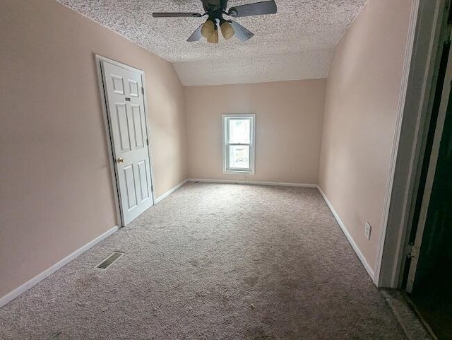 carpeted empty room featuring visible vents, baseboards, a textured ceiling, and a ceiling fan