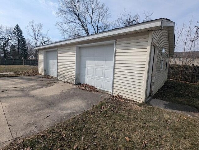 detached garage featuring fence