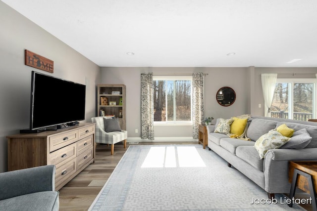 living area featuring recessed lighting, light wood-type flooring, and baseboards