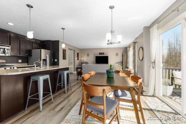 dining room featuring an inviting chandelier, recessed lighting, baseboards, and light wood finished floors