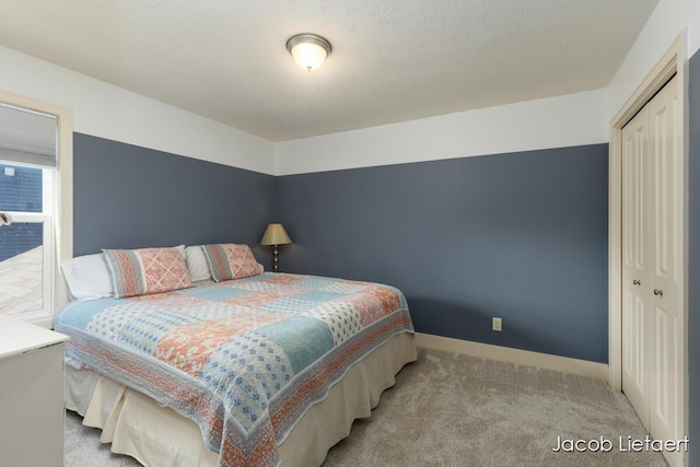 carpeted bedroom with baseboards and a closet