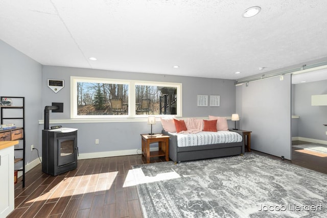 living area with recessed lighting, baseboards, wood tiled floor, and a wood stove