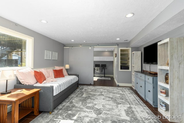 living area with recessed lighting, baseboards, and a textured ceiling