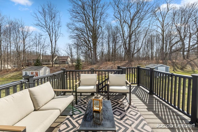 wooden terrace featuring an outbuilding, an outdoor hangout area, and a storage shed