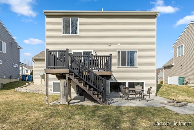 back of house with a wooden deck, a patio, a lawn, and stairs