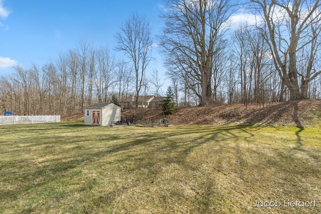 view of yard with a storage shed, fence, and an outdoor structure