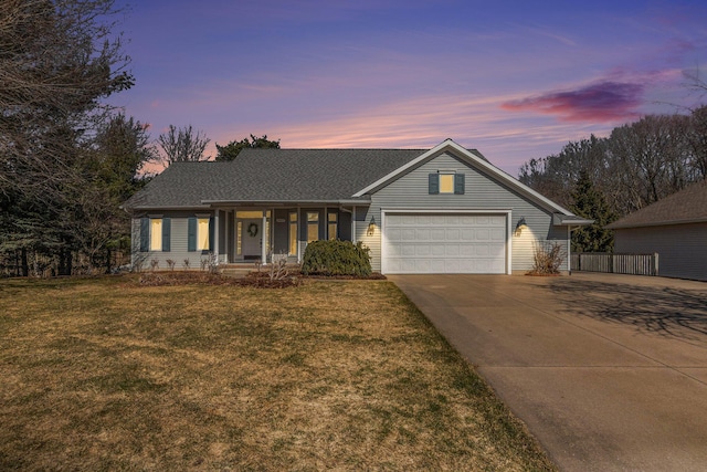 ranch-style home with a garage, driveway, and a front lawn