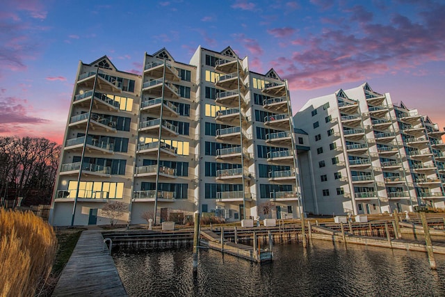 property at dusk with a water view