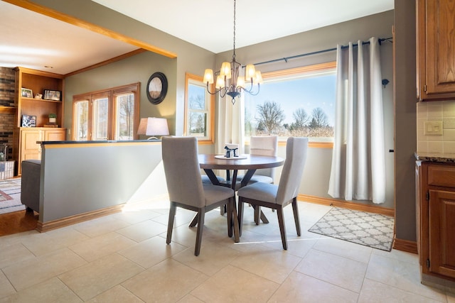 dining space featuring plenty of natural light, baseboards, and a chandelier