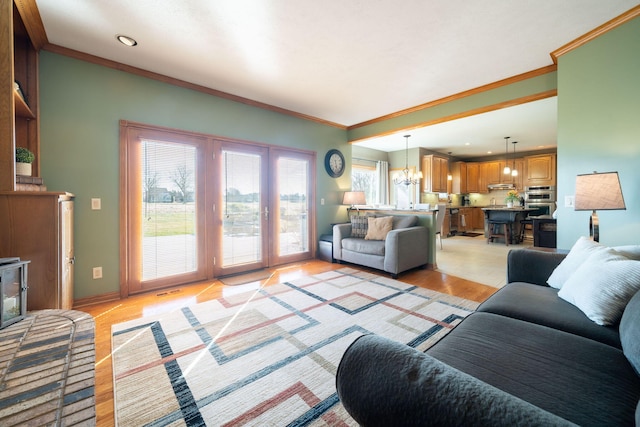 living area featuring crown molding, baseboards, a chandelier, recessed lighting, and light wood-style flooring