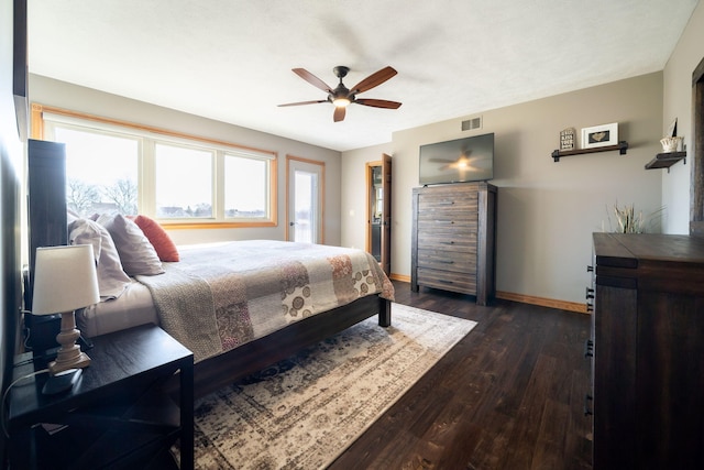 bedroom featuring dark wood-style floors, visible vents, a ceiling fan, and baseboards