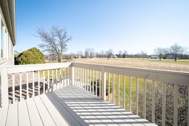 wooden terrace featuring a yard and a rural view