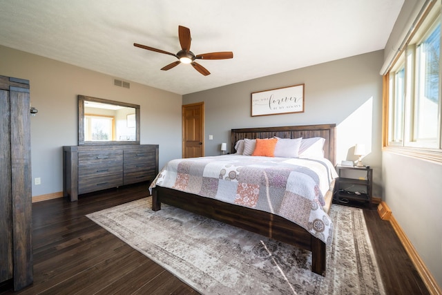 bedroom with visible vents, baseboards, dark wood-type flooring, and ceiling fan