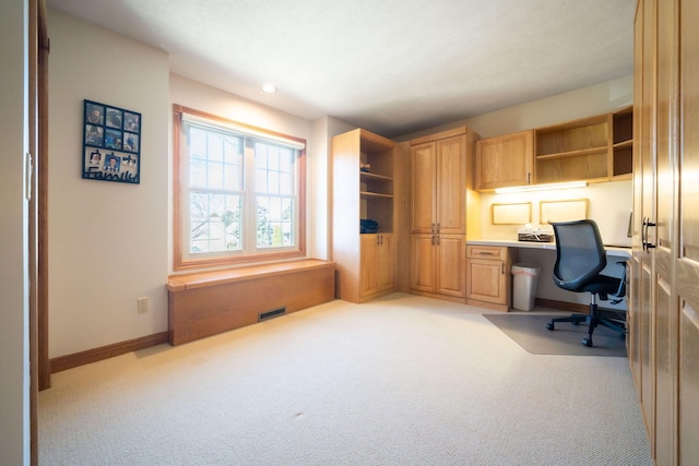 office with light carpet, visible vents, baseboards, and built in study area