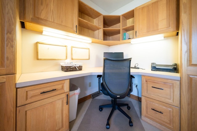 home office featuring built in desk and baseboards