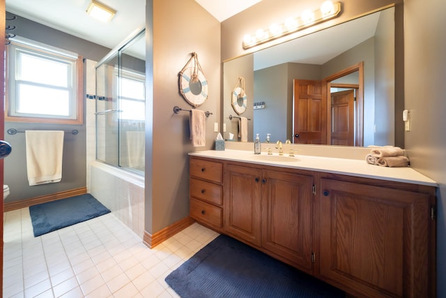 full bathroom with vanity, baseboards, tile patterned flooring, toilet, and tiled shower / bath