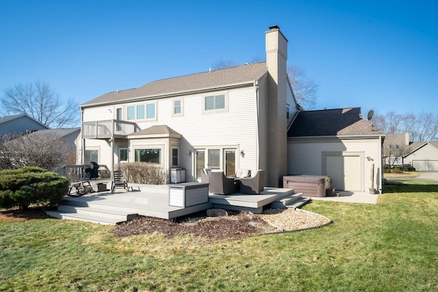 back of house with a balcony, a chimney, a hot tub, a deck, and a lawn