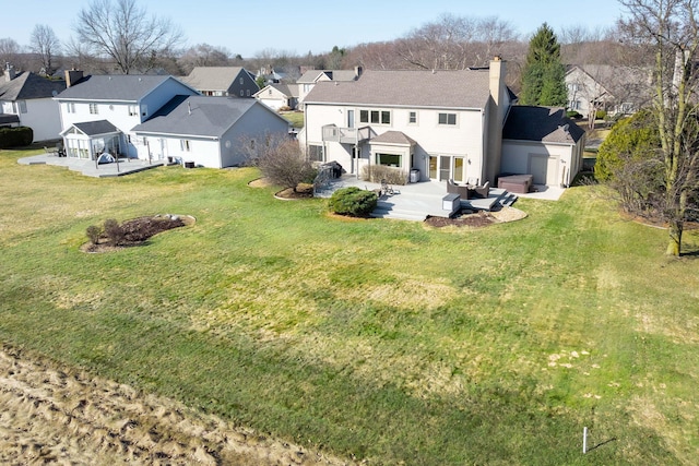 back of house featuring a lawn, a residential view, and a chimney