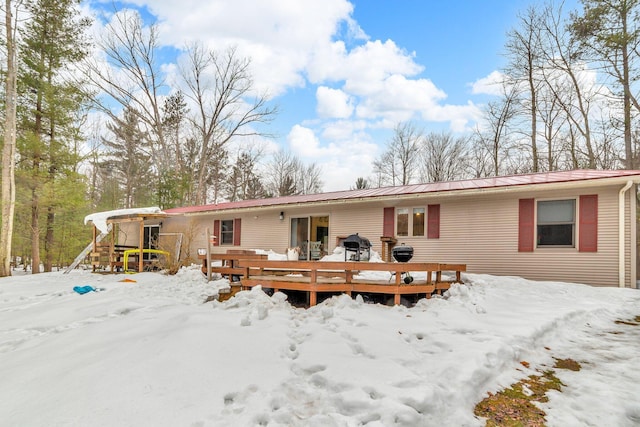 view of front of house with metal roof and a wooden deck