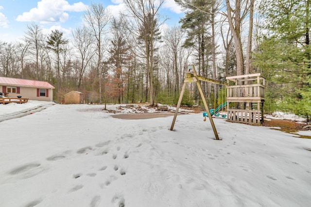 yard layered in snow with a playground