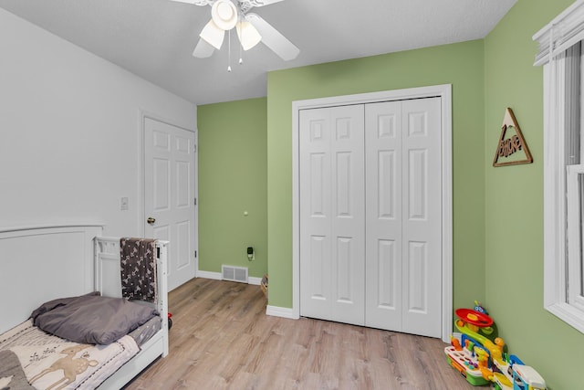 bedroom with visible vents, ceiling fan, baseboards, light wood-type flooring, and a closet