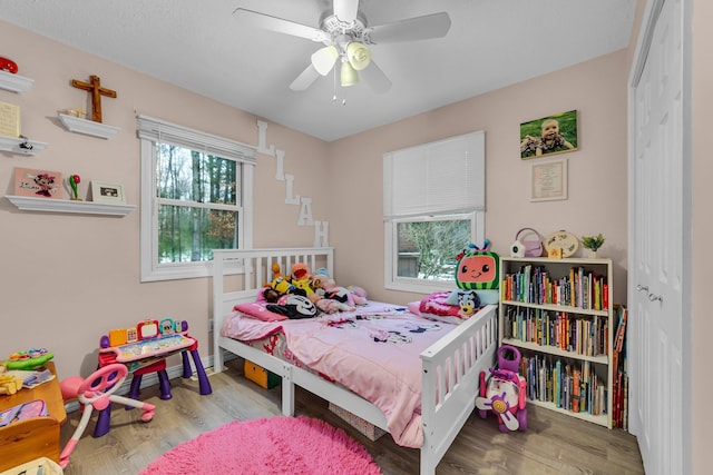 bedroom featuring ceiling fan, a closet, and wood finished floors