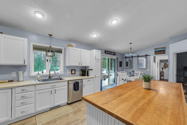 kitchen with a sink, stainless steel dishwasher, white cabinets, and butcher block counters