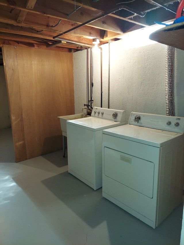 laundry area featuring washer and clothes dryer, laundry area, and a sink