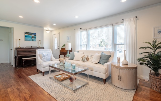 living room with recessed lighting, baseboards, ornamental molding, and light wood finished floors