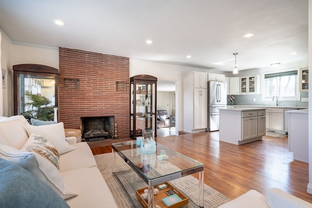 living room with recessed lighting, a fireplace, and light wood-type flooring