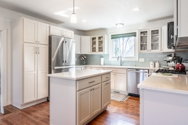 kitchen with wood finished floors, tasteful backsplash, and stainless steel appliances