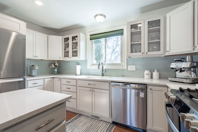 kitchen with a sink, visible vents, appliances with stainless steel finishes, and decorative backsplash